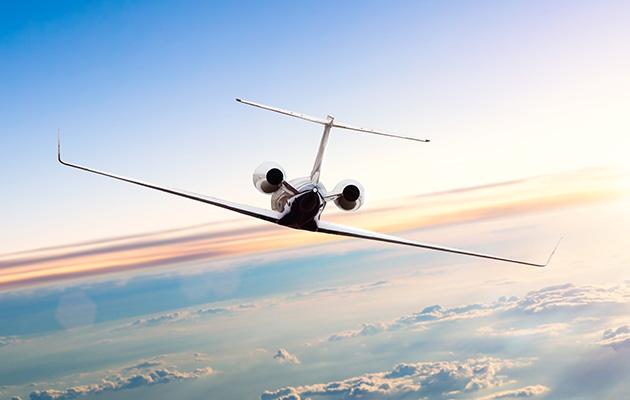 Private jet plan flying above clouds